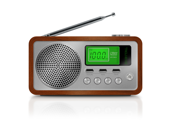 Digital portable radio with green illuminated lcd display. Radio has a wooden body, metallic buttons and antenna. Isolated on white background.